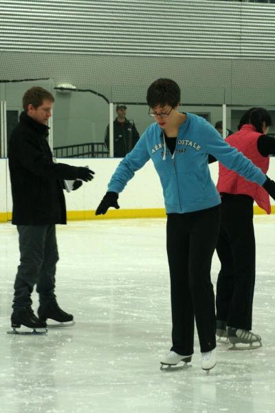 Coach Nick giving hands-on skating instruction on the ice
